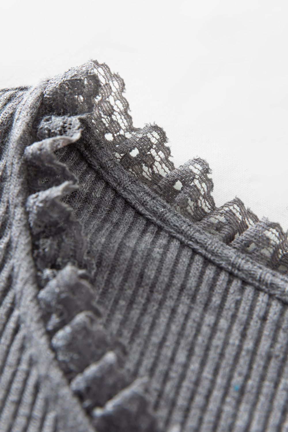 Close-up of ruffle trim on gray ribbed dress
