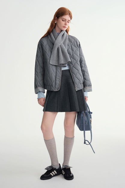 Side view of model in gray quilted jacket and skirt