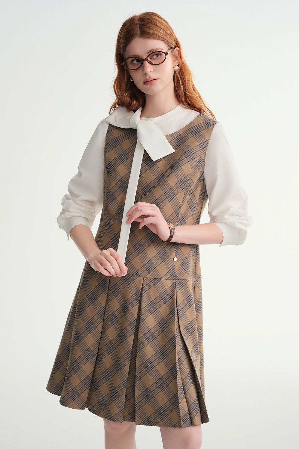 Full front view of model in plaid dress with white bow blouse