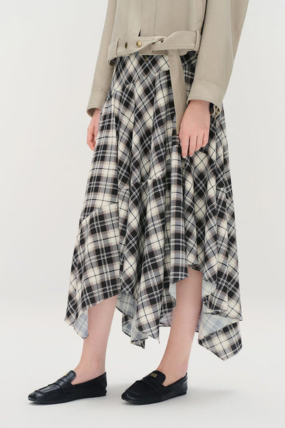 Side view of black, white, and brown plaid asymmetrical skirt showing uneven hem