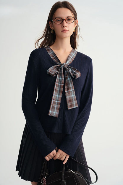 Front view of navy blue pleated skirt outfit with plaid bow detail
