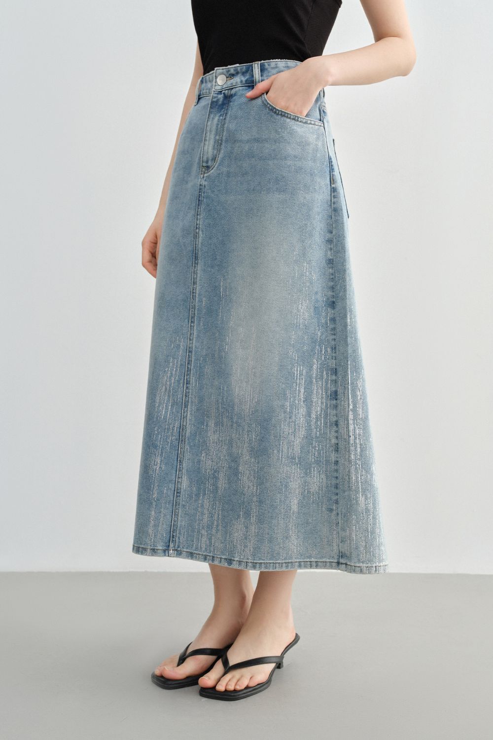 Side view of light blue A-line denim skirt with clean seam details