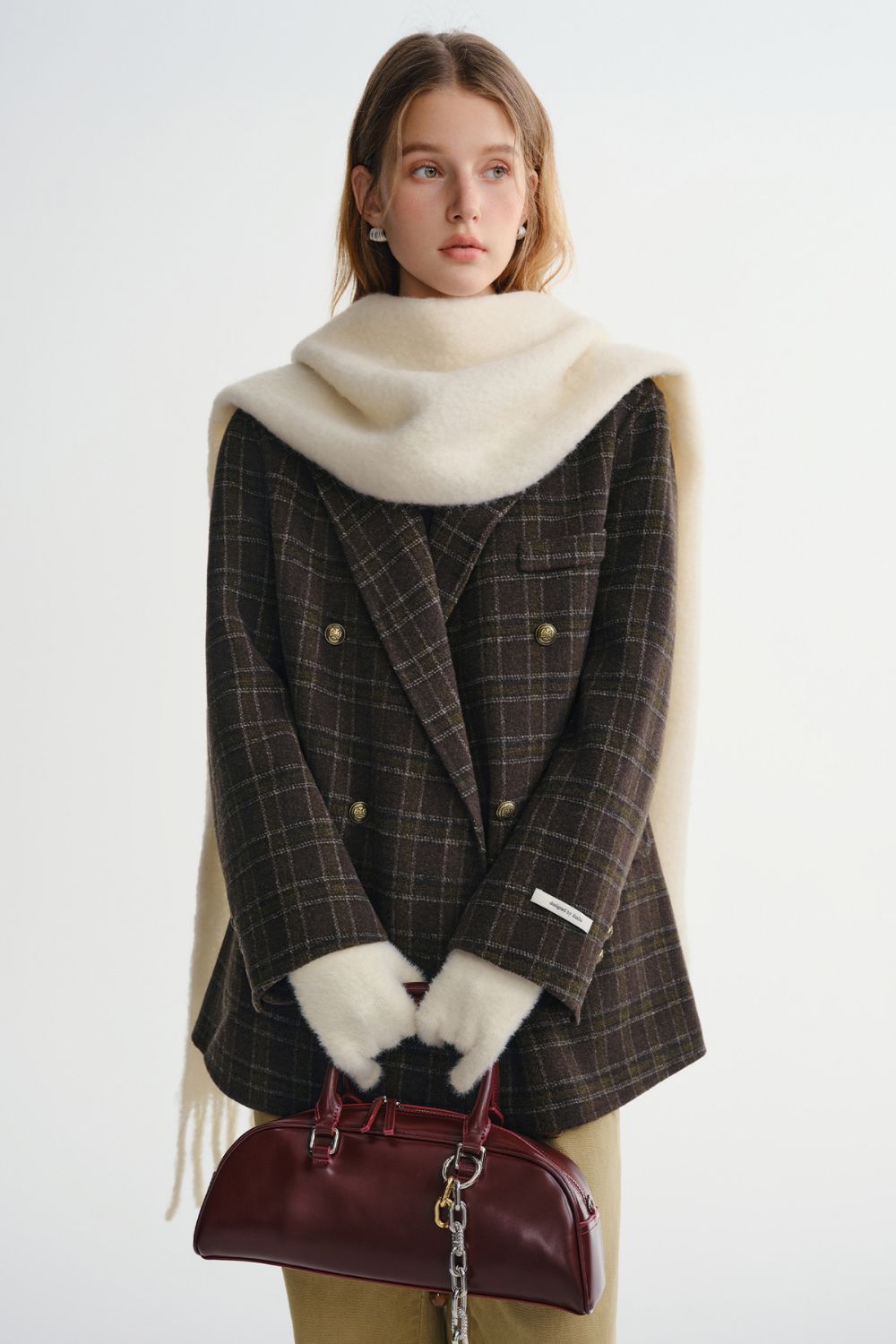 Front view of plaid coat styled with a white scarf and gloves