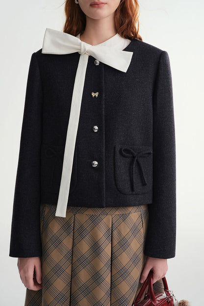 Close-up front view of black cropped jacket with button closure and pocket details