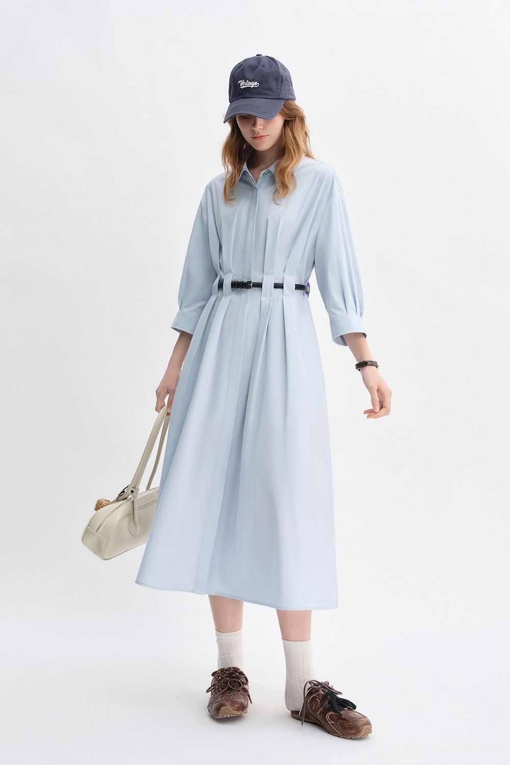 Angled view of light blue belted long-sleeve dress styled casually