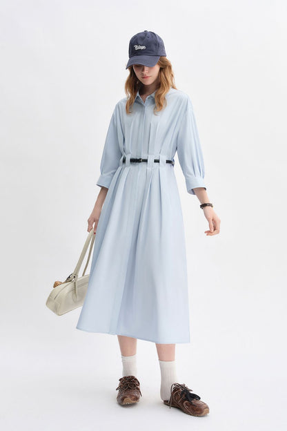 Angled view of light blue belted long-sleeve dress styled casually