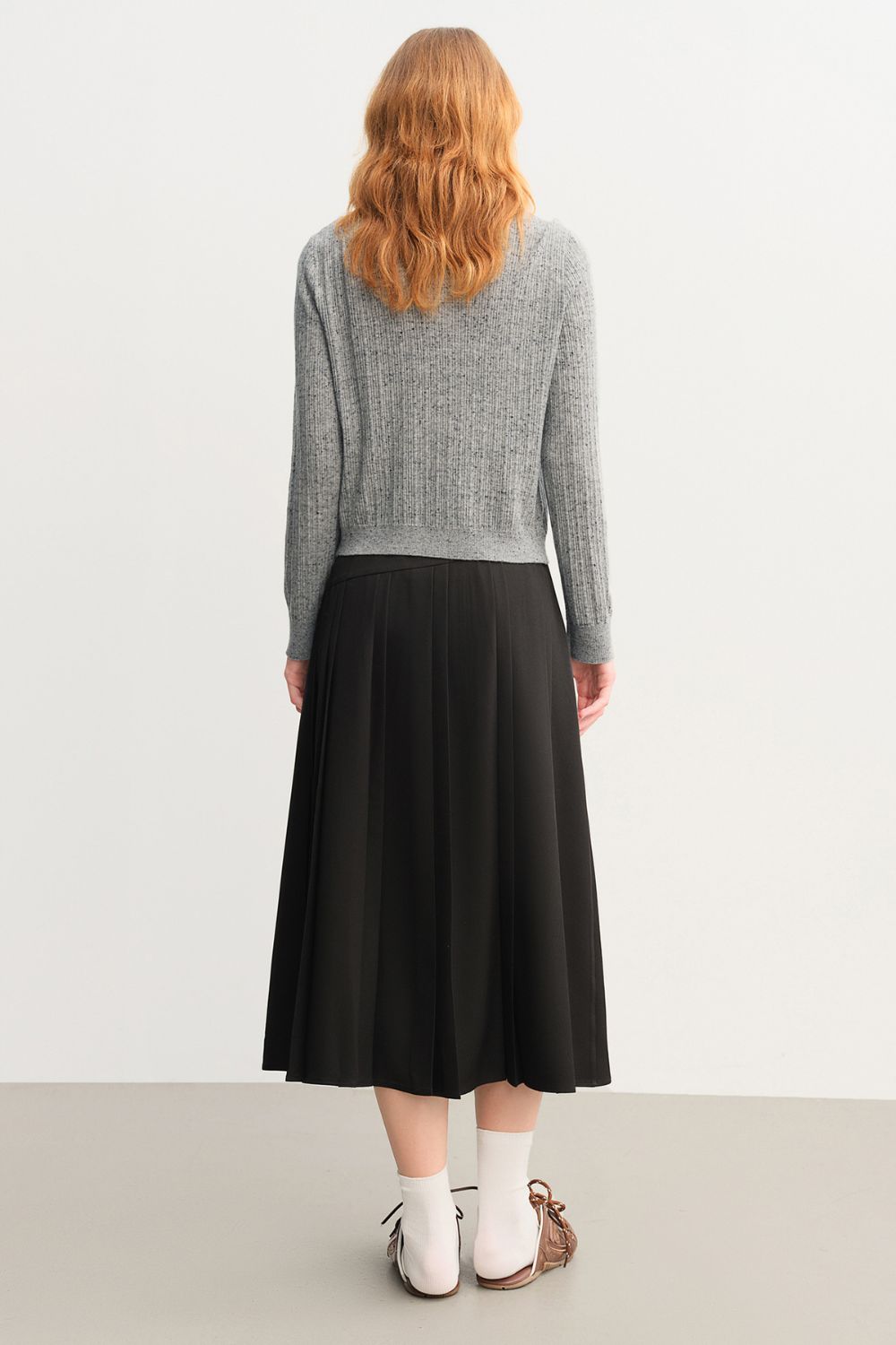 Back view of black pleated midi skirt with defined pleats