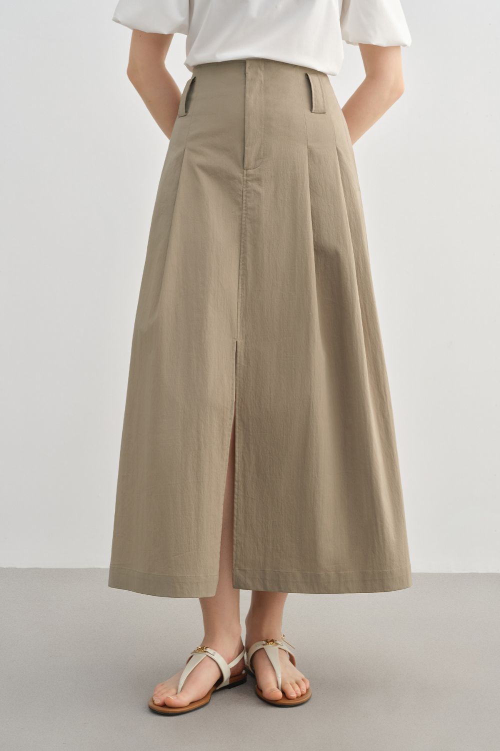 Full front view of beige midi skirt styled with a white blouse