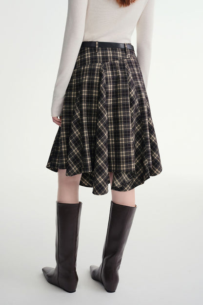 Back view of plaid skirt showing flared hemline with knee-high boots