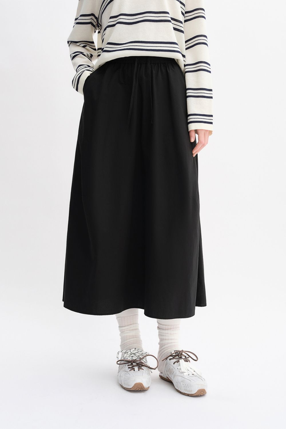 Front view of black maxi skirt paired with striped top