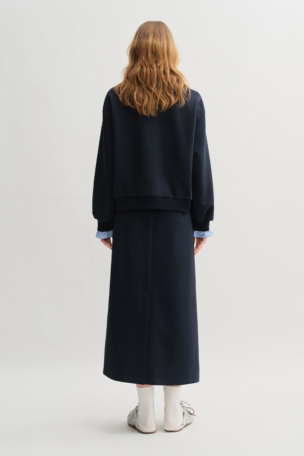 Rear view of navy blue pullover and skirt set