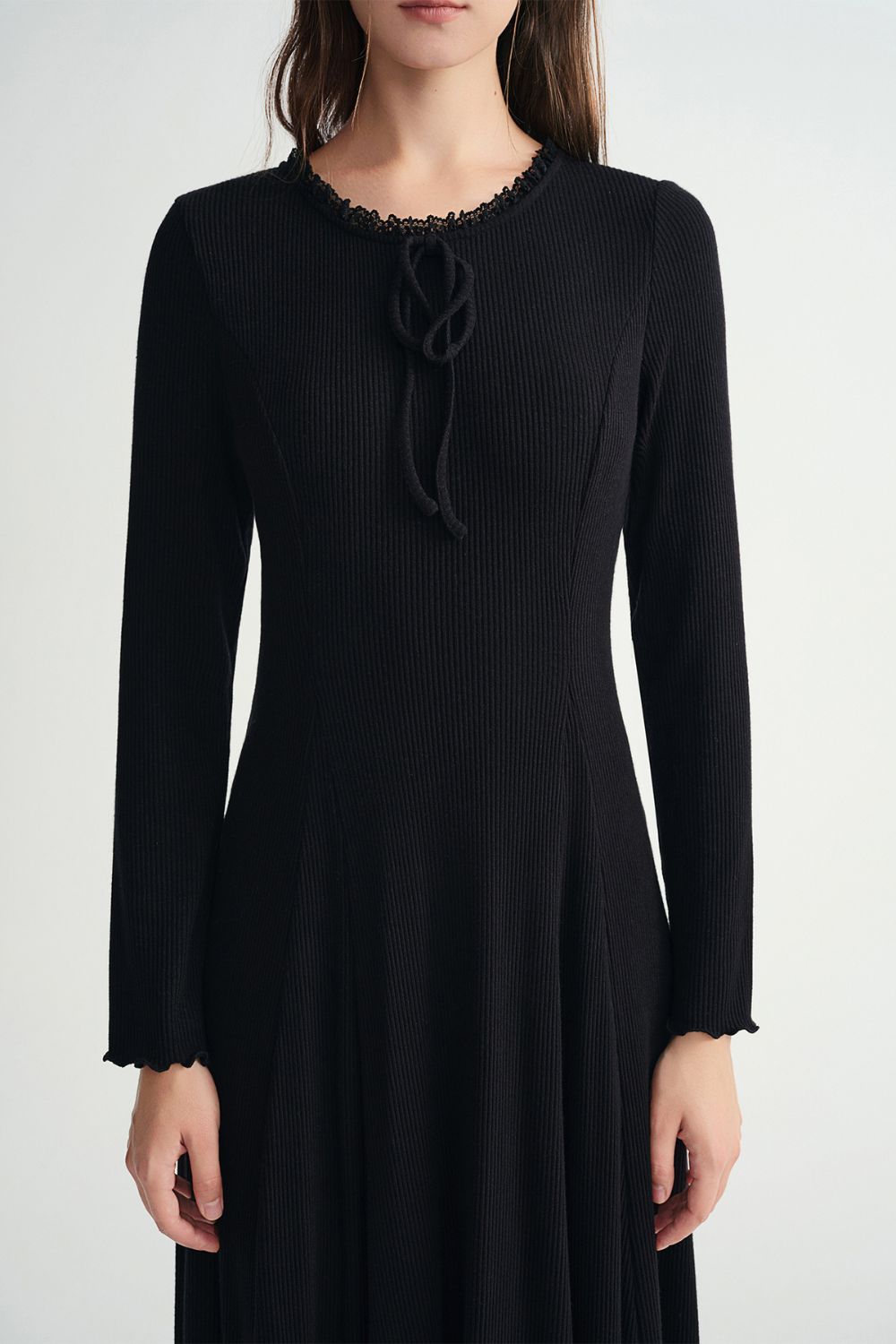 Model styling black ribbed dress with denim jacket and striped scarf