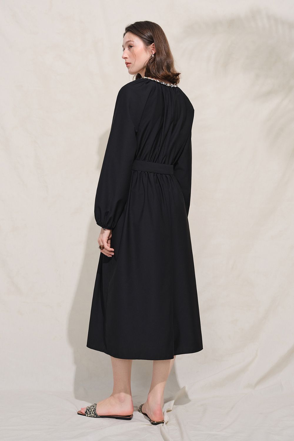 Side view of black long-sleeve midi dress
