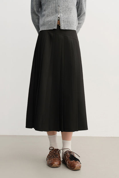 Close-up front view of black pleated midi skirt paired with loafers