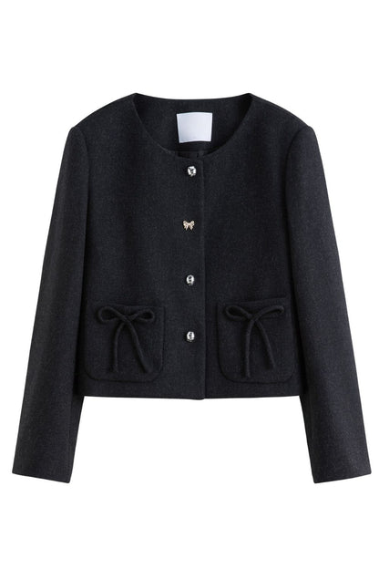 Flat lay of black cropped jacket with buttons and flap pockets