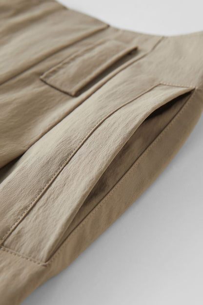 Close-up of beige skirt’s fabric texture and stitching