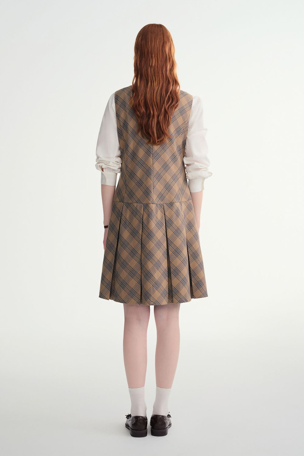 Back view of brown plaid A-line dress with white blouse underneath