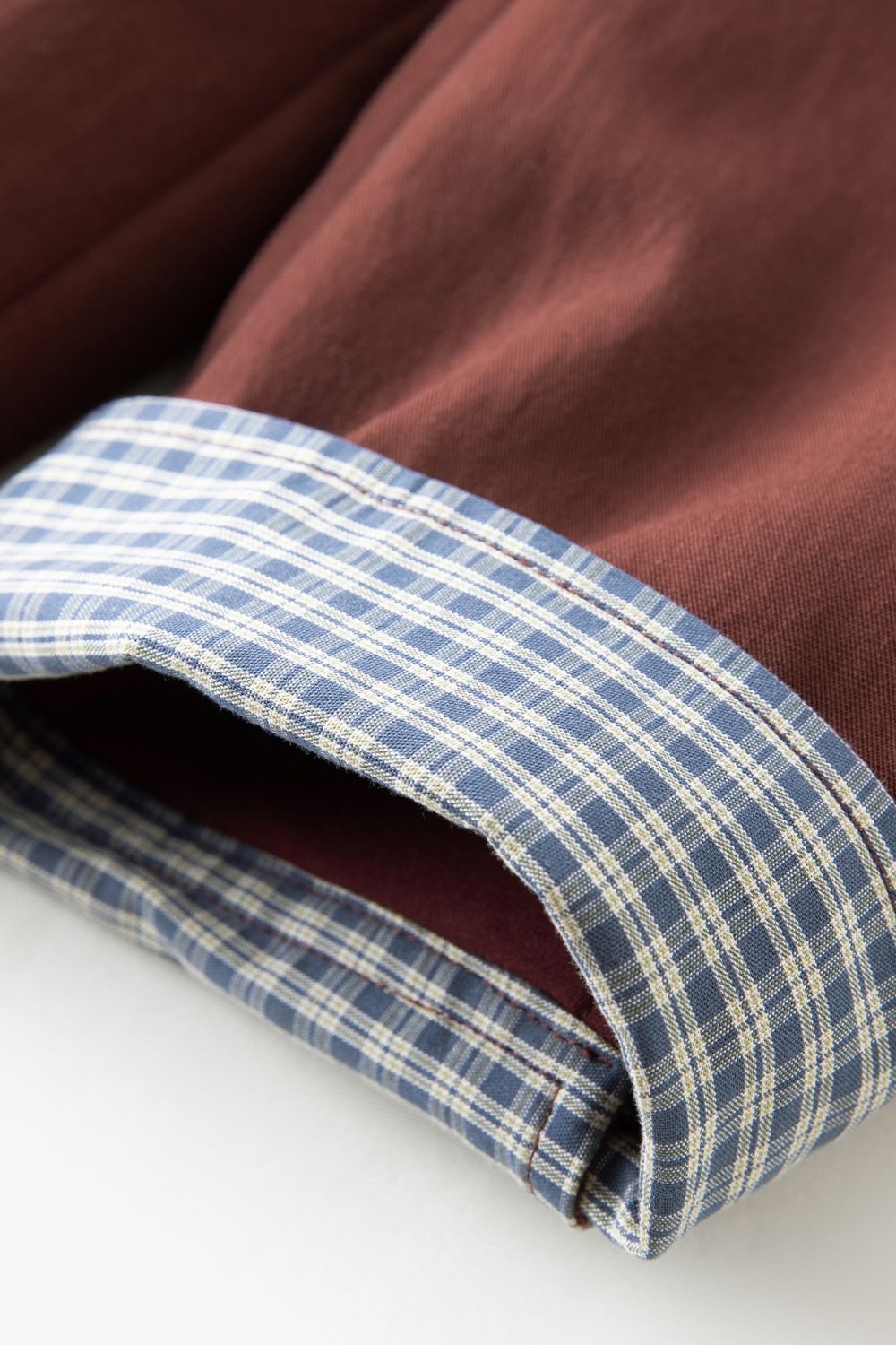 Close-up of brown jacket cuff with blue check lining