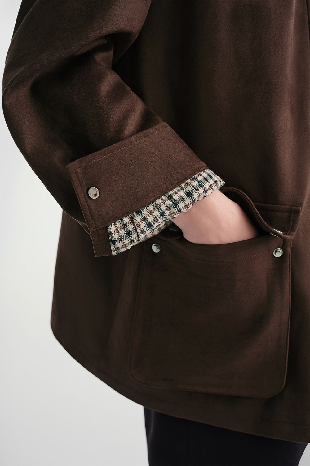 Close-up of pocket detail on brown button-up jacket