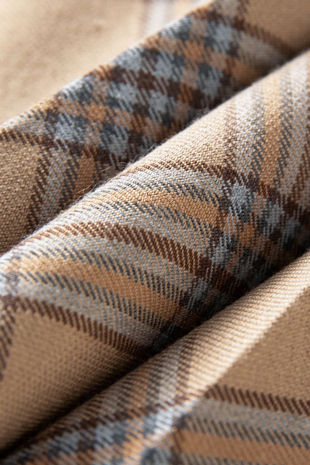 Close-up of brown plaid fabric with blue and beige accents