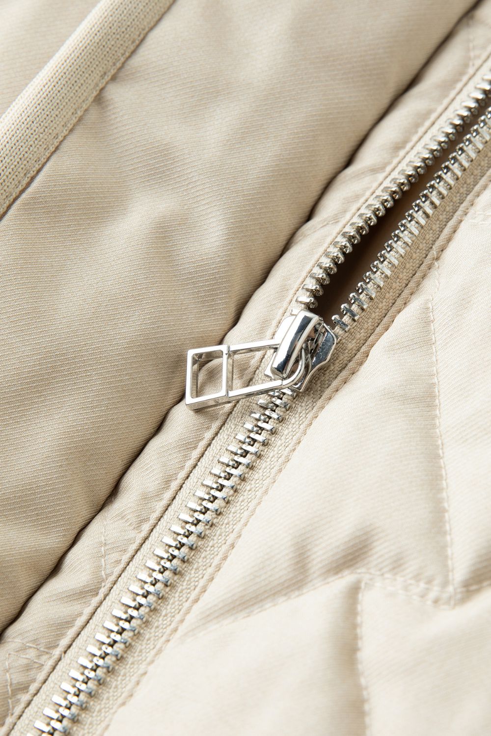 Close-up detail of beige jacket zipper 
