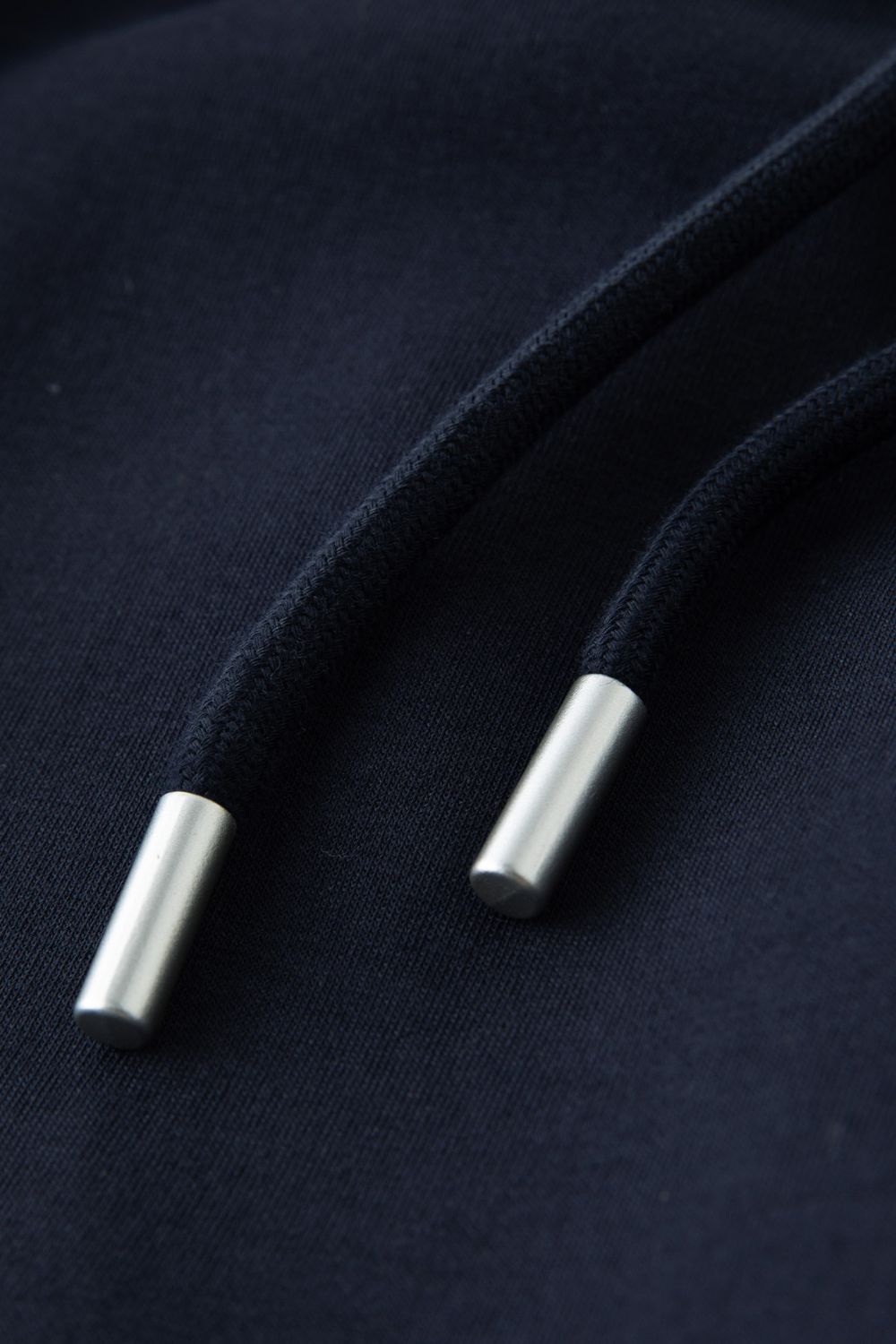 Close-up of silver drawstring tips on navy blue skirt waistband