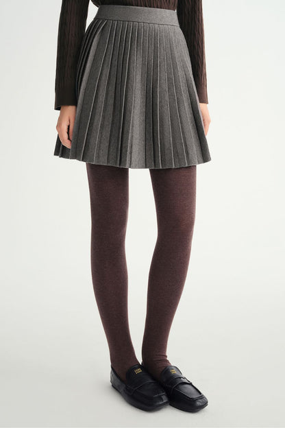 Close-up of gray pleated skirt with black tights and shoes