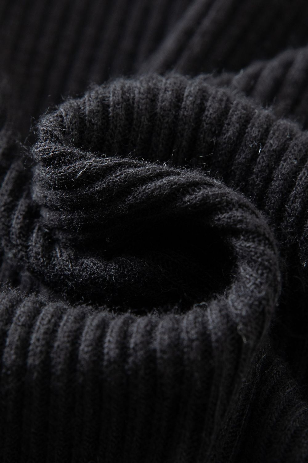 Fabric texture close-up of black ribbed knit material