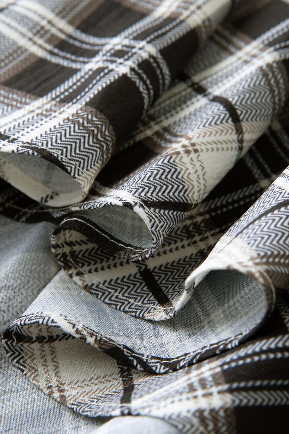 Close-up detailed view of plaid skirt with flowy hemline