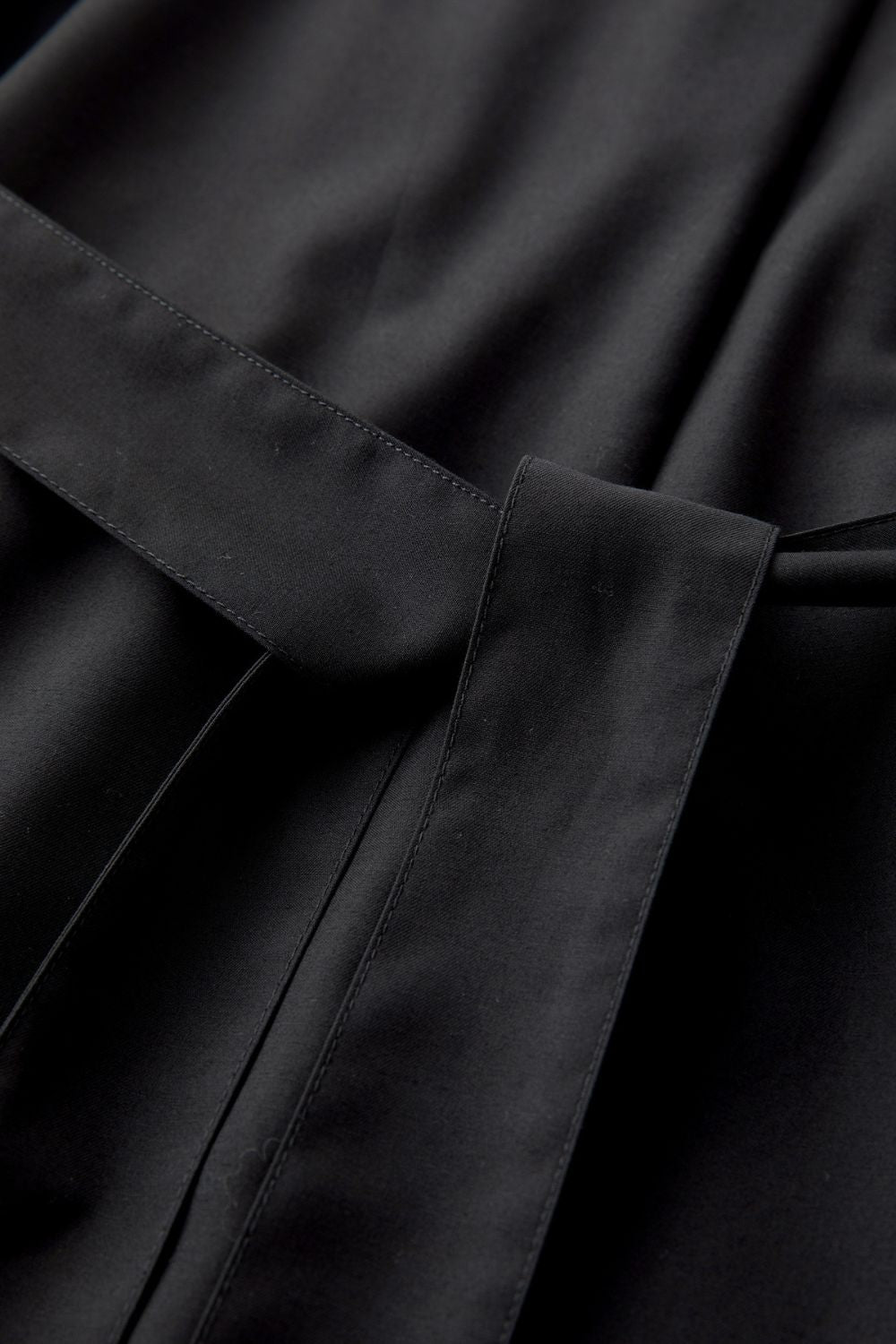 Close-up of fabric texture and stitching on black dress