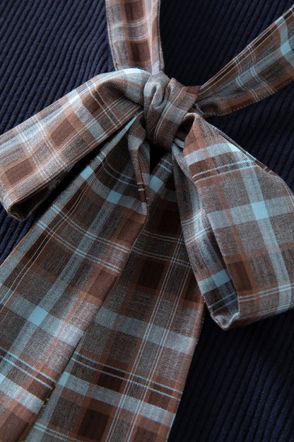 Close-up of brown and navy blue plaid bow detail