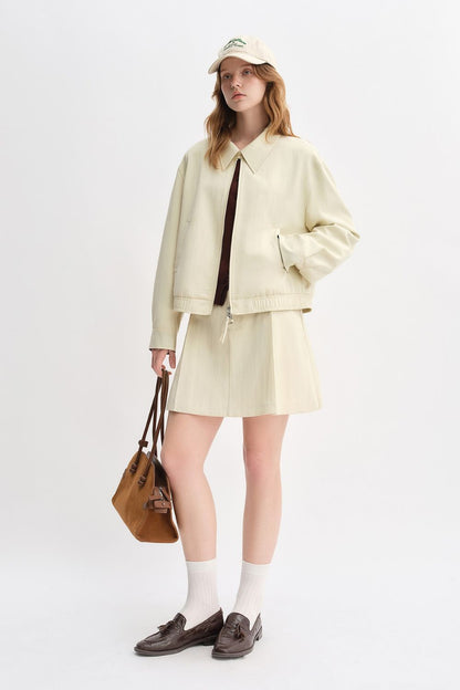 Model in cream jacket and skirt set with crossbody bag