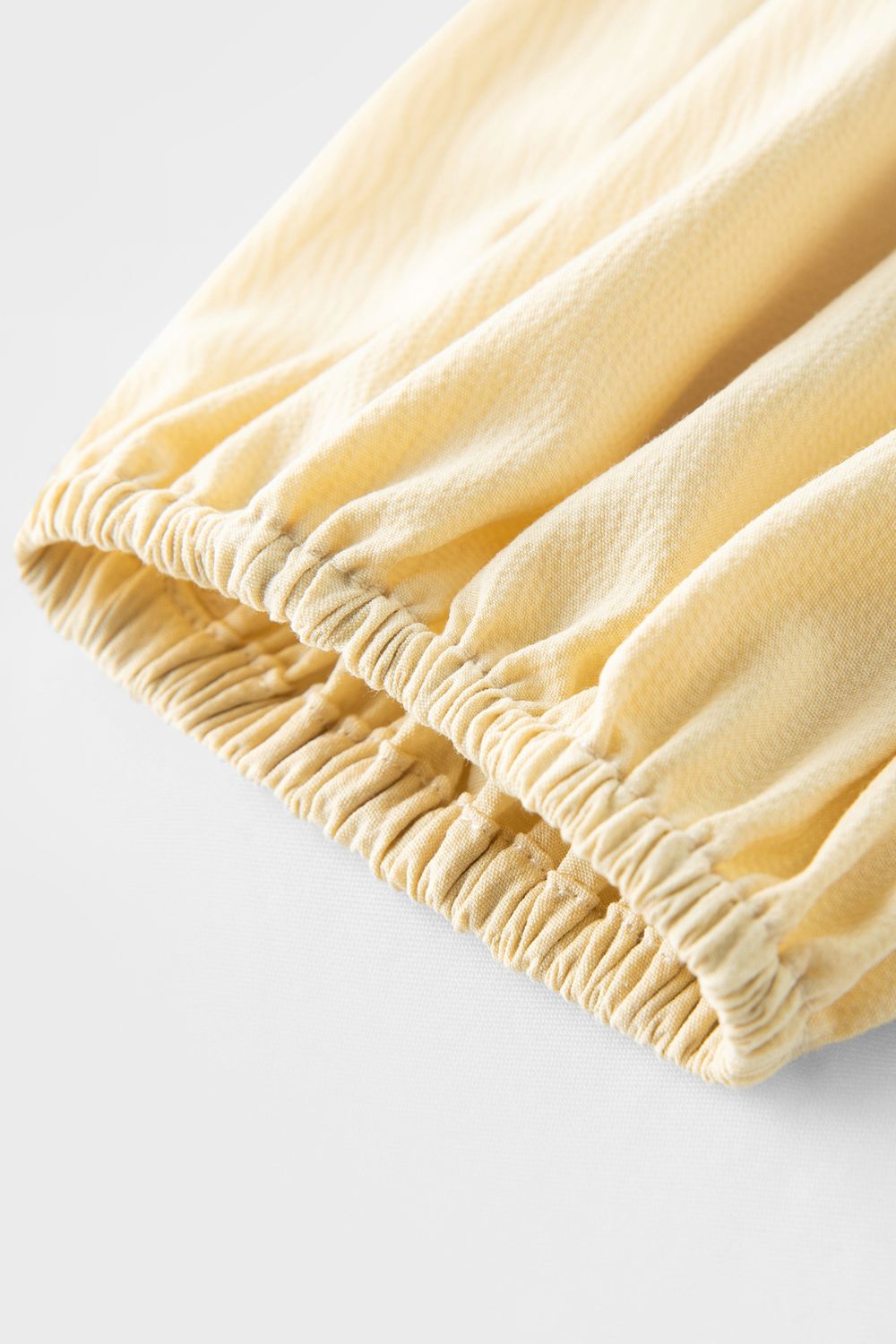 Close-up of gathered cuff sleeve detail on yellow dress