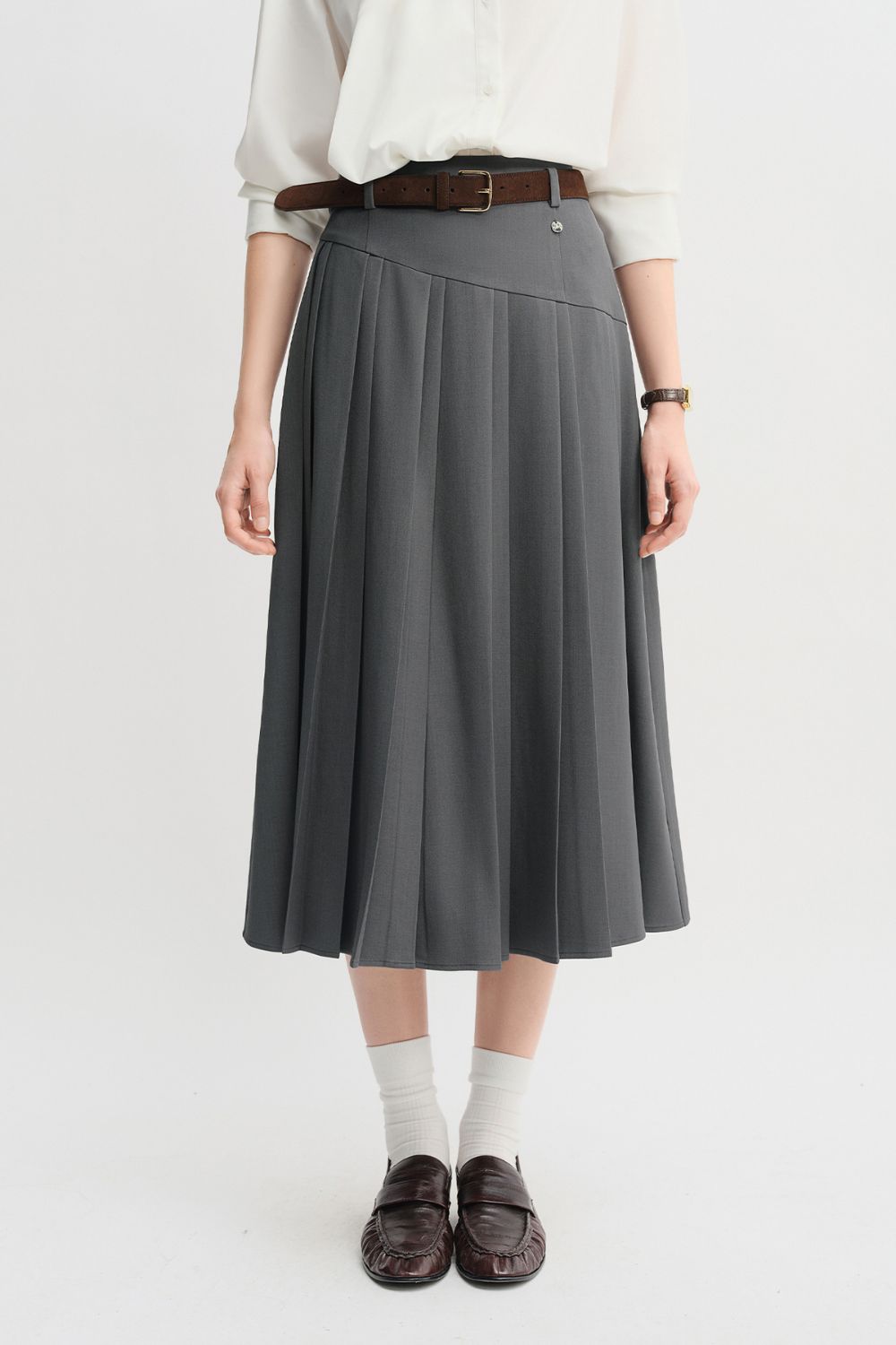 Front view of gray pleated midi skirt styled with a belt
